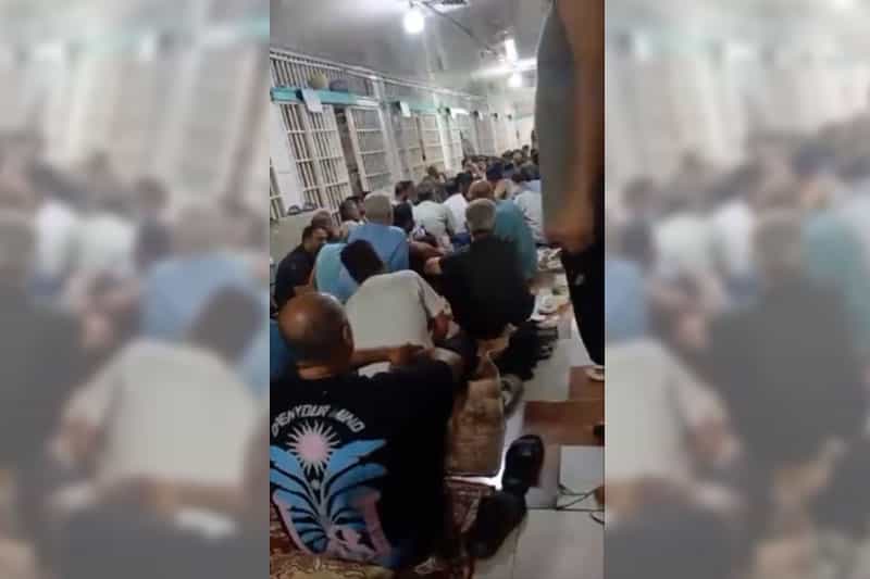 زندانیان واحد ۲ زندان قزلحصار کرج روی زمین کریدور زندان پشت به دوربین نشسته‌اند.