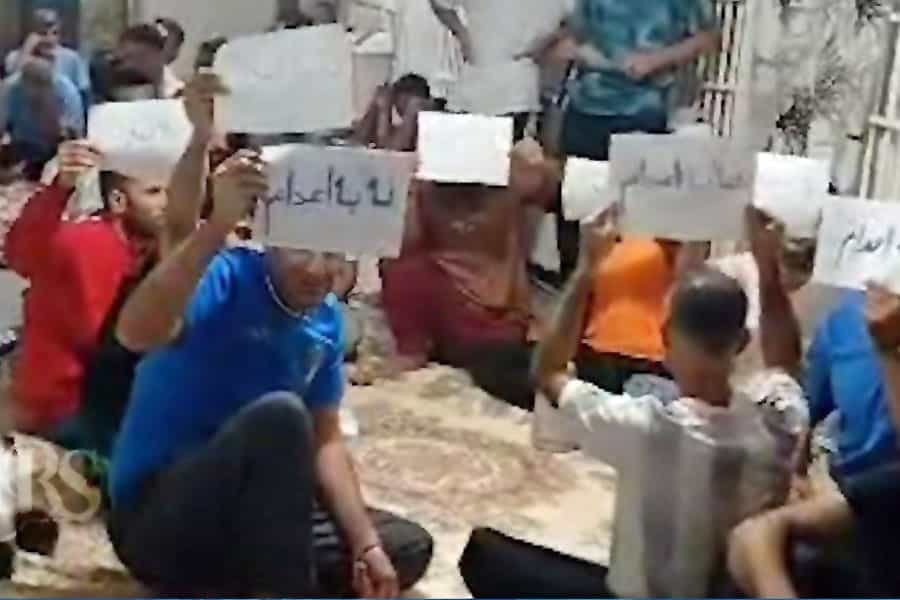 چند تن از زندانیان اعتصابی کاغذهایی در دست دارند که روزی آن‌ها نوشته شده: «نه به اعدام»