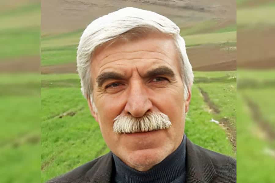چهره جهانگیر رستمی. پشت سر او نمایی از کوه و چمنزار دیده می‌شود.