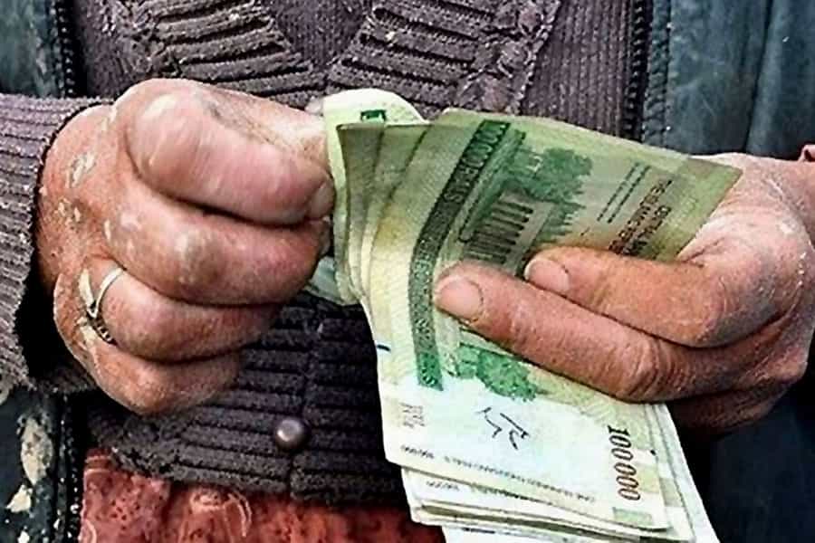 انگشتان یک کارگر در حال شمردن اسکناسها هستند.