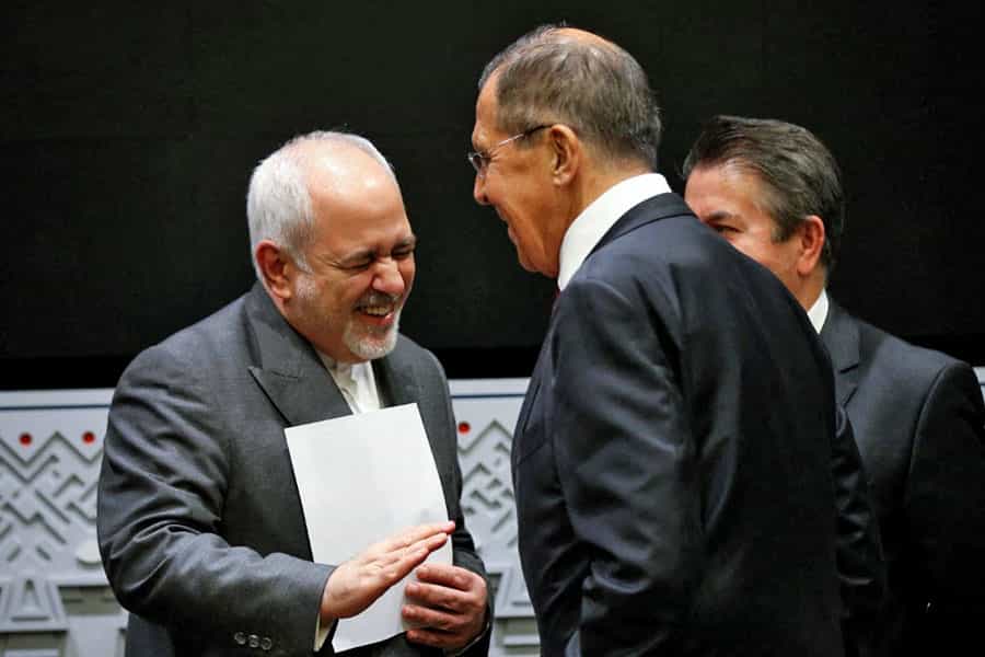 محمدجواد ظریف و سرگئی لاوروف روبه‌روی هم ایستاده و می‌خندند. در دست طریف یک برگه هست.