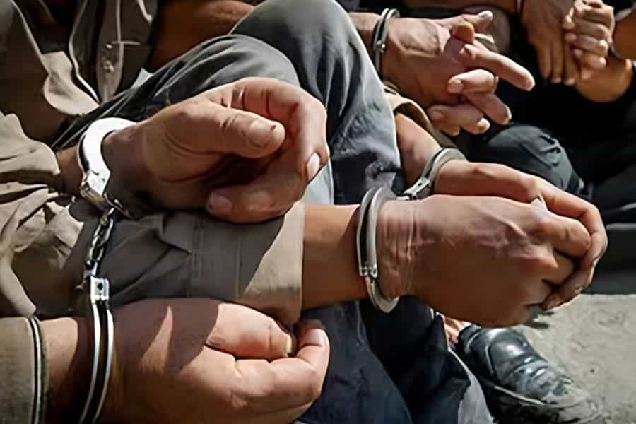 تصویری از چند دست که دستبند بازداشت دارند.