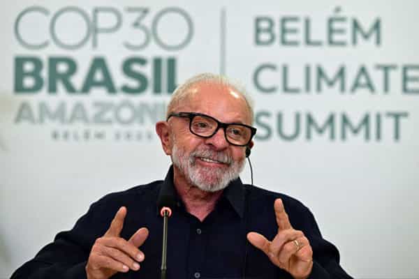 لولا داسیلوا، رئیسجمهور برزیل پشت میکروفون میخندد و پشت سر او لوگوی کنفرانس تغییرات اقلیمی سازمان ملل متحد «کاپ۳۰» دیده میشود.