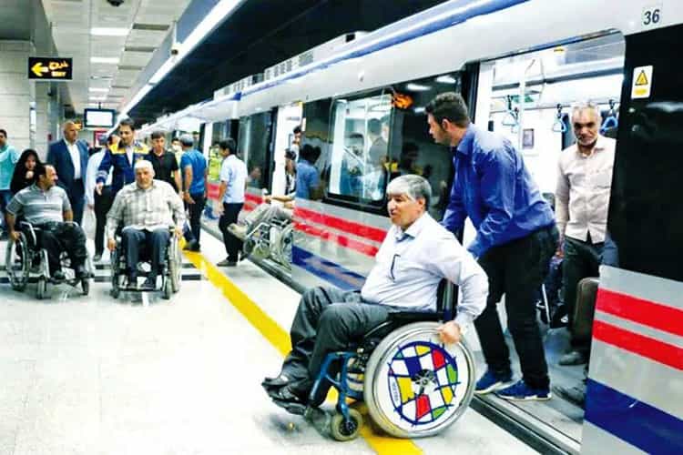 مردی روی فیلچر نشسته است و کسی او را از واگن مترو خارج می‌کند. دو مرد دیگر در دور دست روی فیلچر نشسته‌اند.