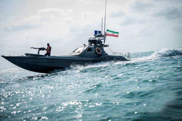 در تصویر یک قایق تندرو در دریا دیده می‌شود که یک عضو سپاه پاسداران پشت مسلسلی که روی آن قرار دادرد ایستاده و پرچم جمهوری اسلامی نیز روی قایق نصب شده است.