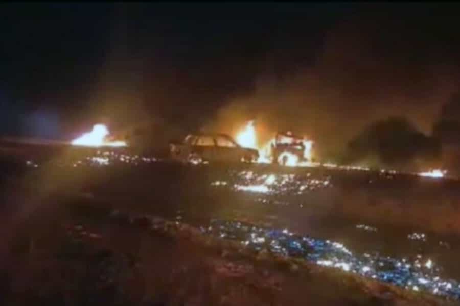 در تاریکی شب یک خودروی سواری در آتش می‌سوزد.