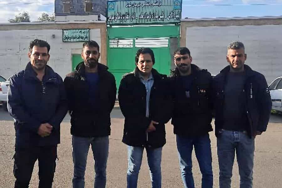 پنج کارگر اعتصابی شرکت قند خاورمیانه شوش در مقابل ورودی این کارخانه ایستادهاند.