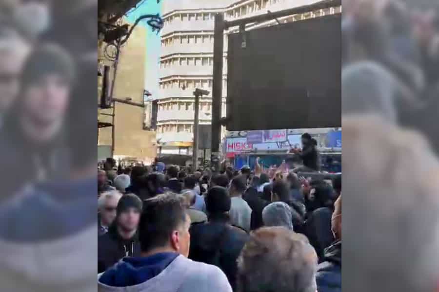 جمعیت زیادی در یک هوای آفتابی سرد در خیابان دیده می‌شود