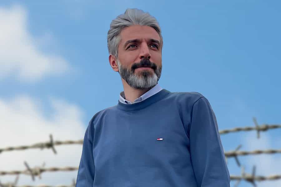 تصویری از چهره احسان رستمی. پشت سر او سیم خاردار دیده میشود