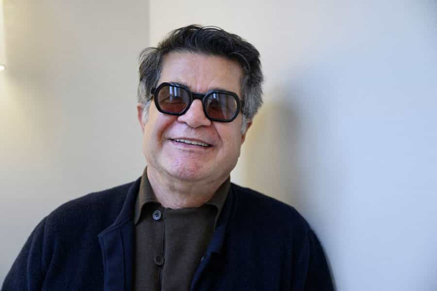 جعفر پناهی در کریدور یک هتل در استکهلم رو به دوربین می‌خندد.