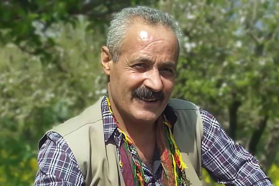 تصویری از چهره کاوه احمدزاده در لباس کُردی که به دوربین لبخند میزند.