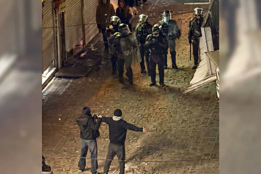 دختر و پسر جوانی در برابر چند مأمور امنیتی ایستاده‌اند.