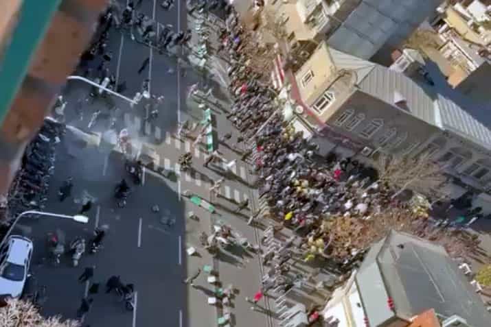 نمایی دور و از بالا، از خیابان جمهوری تهران که در آن مردم معترض تجمع کرده‌اند و نیروهای نظامی هم حضور دارند.