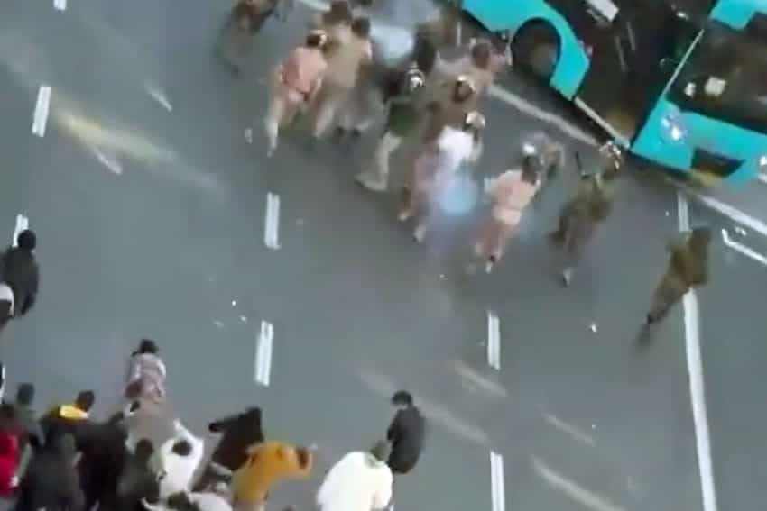 نمایی دور و از بالا، از خیابان جمهوری تهران که در آن مردم معترض به نیروهای امنیتی حمله کرده‌اند.