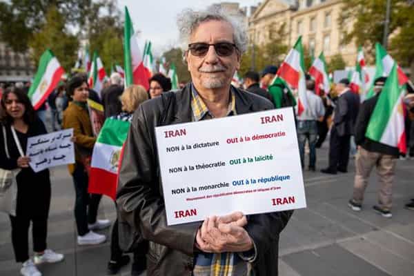 شیدان وثیق در میان تظاهرکنندگان پلاکاردی به زبان فرانسوی در دست دارد که روی آن نوشته شده: «نه به دیکتاتوری، آری به دموکراسی«، «نه یه دینسالاری، آری به لائیسیته» و «نه به پادشاهی، آری به جمهوری»