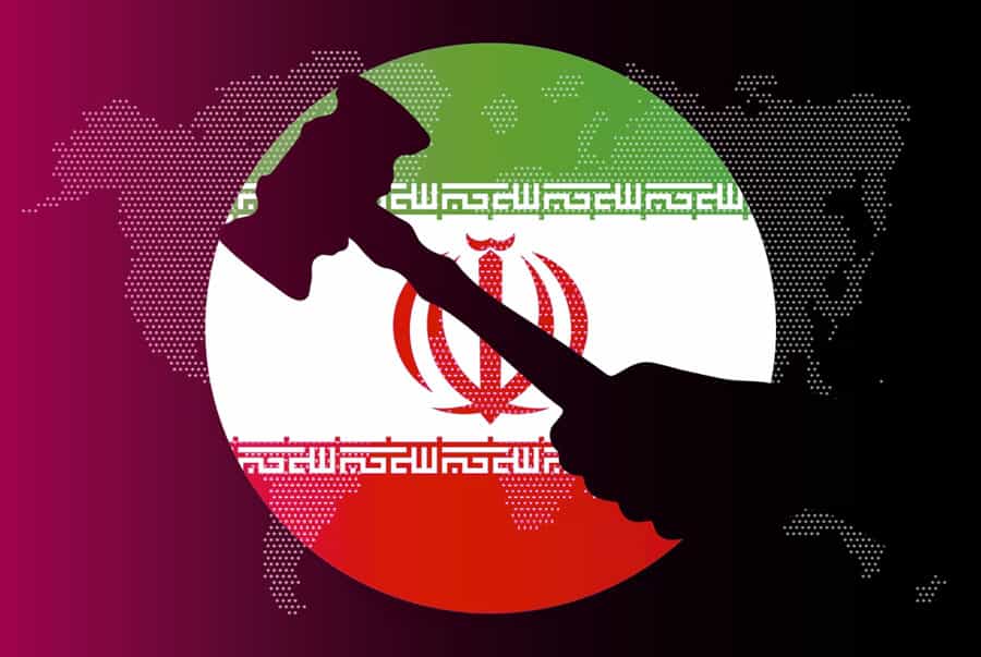 نمایی از نقشه کره زمین در تاریکی: دایره‌ای در میان نقشه با پرچم جمهوری اسلامی ایران باز شده است و دست تیره‌ای که چکشی در دست دارد در میان این دایره دیده می‌شود.