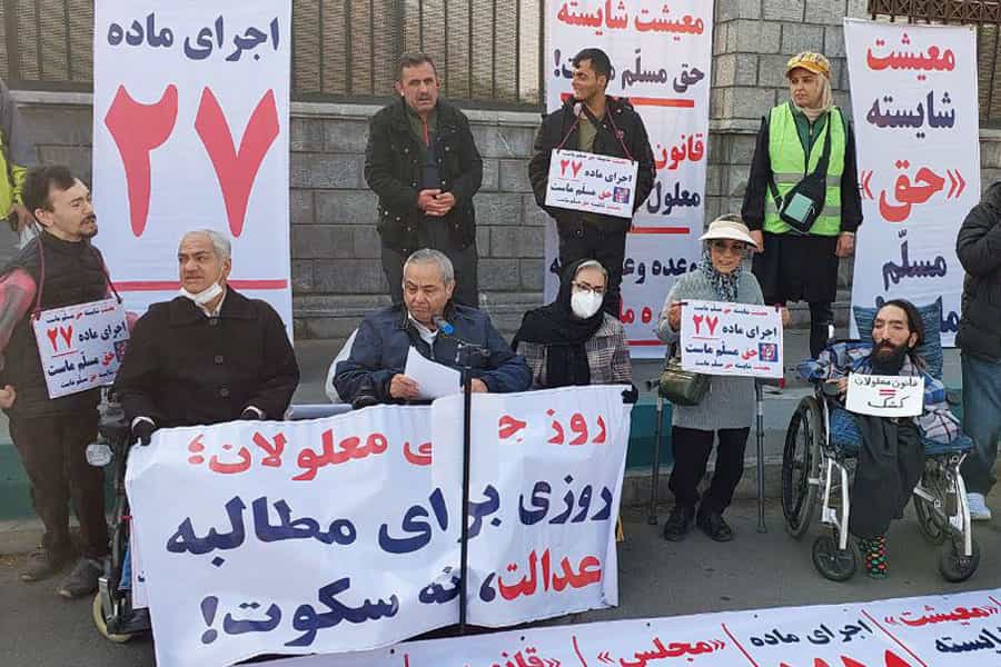 گروهی از افراد دارای معلولیت پلاکاردهایی در دفاع از حقوق خود در دست دارند.