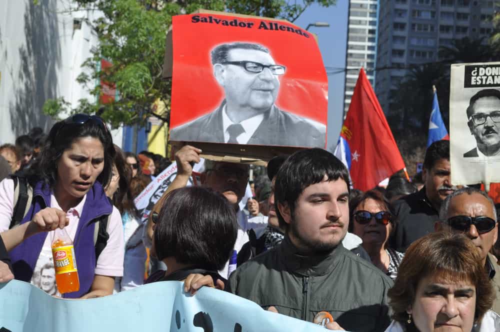 زنان و مردانی در شیلی که تظاهرات کرده اند و کس آلنده را هم در دست دارند