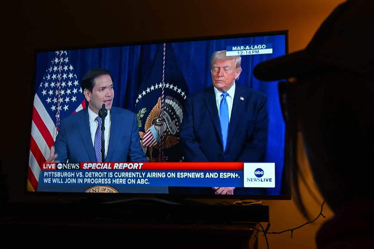 نی در حال تماشای پخش زنده ABC News است که در آن وزیر امور خارجه ایالات متحده، مارکو روبیو، درباره یک عملیات نظامی ویژه ایالات متحده در ونزوئلا صحبت می‌کند، با حضور رئیس‌جمهور دونالد ترامپ، در کراکوف، لهستان، ۳ ژانویه ۲۰۲۶. (عکس از آرتور ویداک / NurPhoto) (عکس از آرتور ویداک / NurPhoto / NurPhoto از طریق AFP)