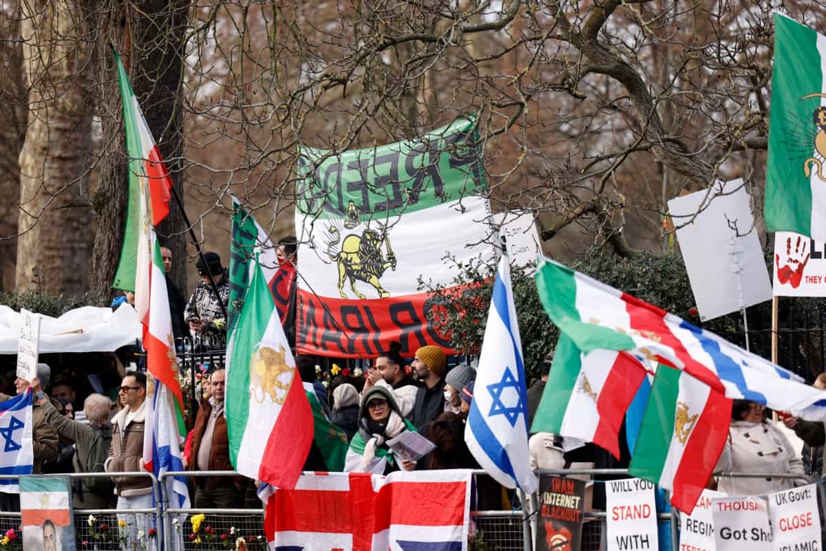 معترضان مخالف رژیم ایران در جریان تظاهرات مقابل سفارت ایران، مرکز لندن، در ۲۴ ژانویه ۲۰۲۶، پرچم‌های ایران را تکان می‌دهند.