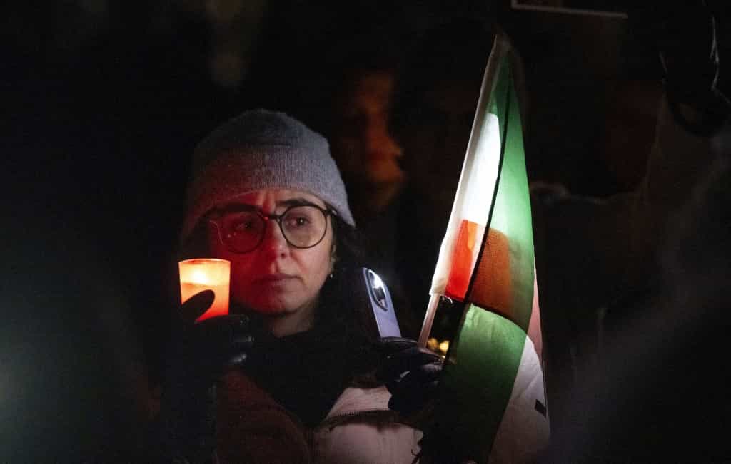 زنی شمعی را در سکوت یک دقیقهای برای قربانیان ناآرامیها در ایران در دست دارد.