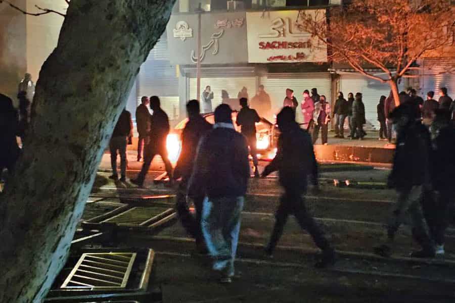 در هوای تاریک شب گروهی از جونان معترض آتش روشن کرده و موانعی در خیابان ایجاد کردهاند.