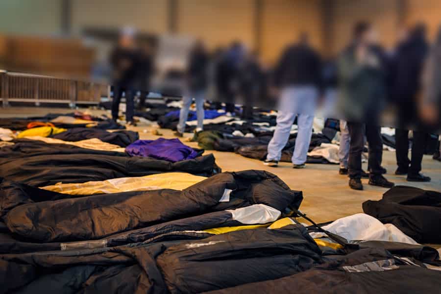 شماری جسد روی زمین یک سالن قرار دارند و عده‌ای در میان آن‌ها در حال شناسایی بستگان خود هستند.