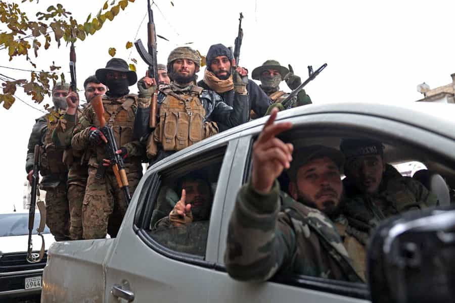 گروهی از نیروهای دولتی سوریه بر روی یک خودروی نظامی دیده می‌شوند. آن‌ها مسلح هستند.