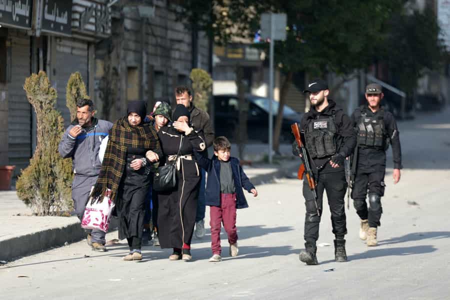 دو تن از نیروهای امنیتی سوریه یک خانواده شش نفره را به سمتی هدایت میکنند.