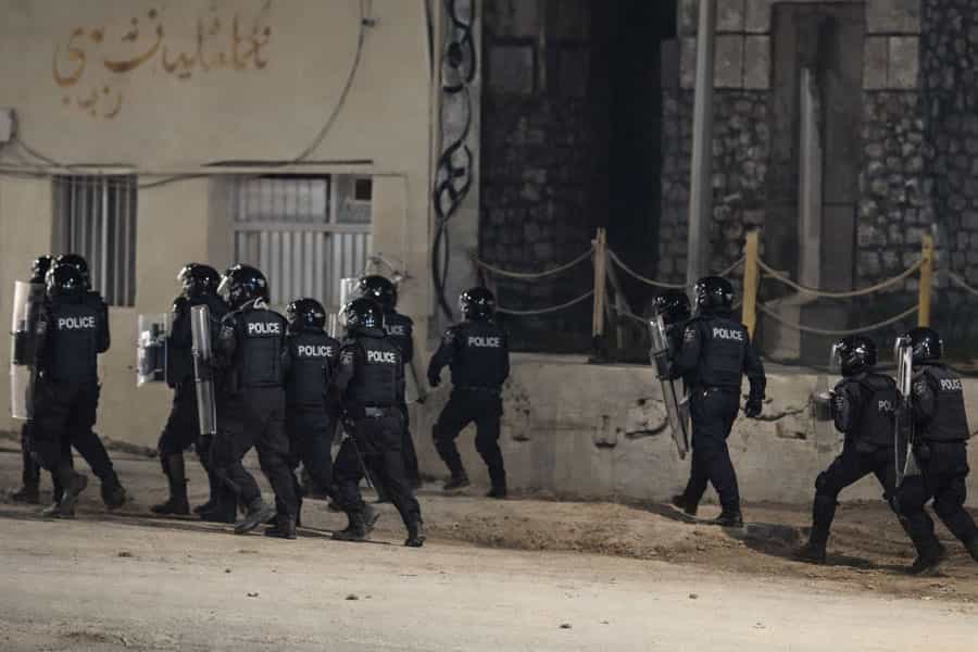 در هوای تاریک شب نیروهای امنیتی جمهوری اسلامی از کوچه‌ای عبور می‌کنند.