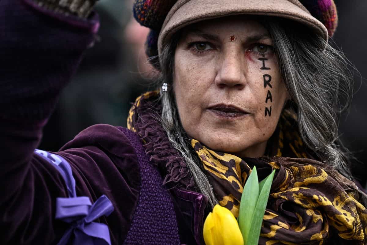 زنی معترض که نام ایران رو روی صورتش نوشته