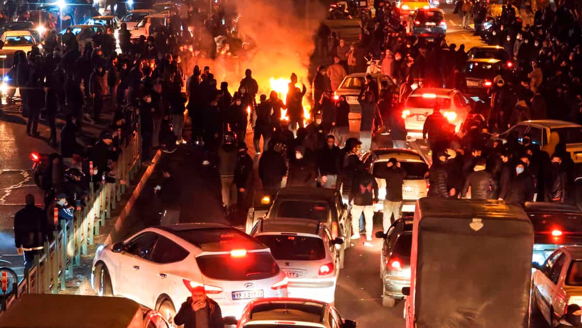 مردم معترض در خیابان و تاریکی و چند ماشین و آتش
