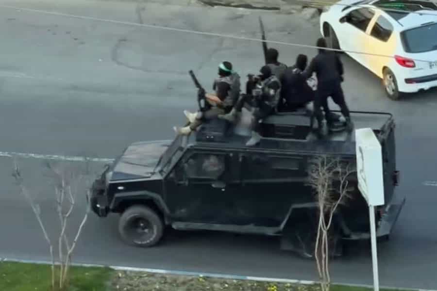 شماری از مأموران ویژه نقابدار جمهوری اسلامی روی یک خودرو نظامی با سلاح هایی در دست گشت زنی می‌کنند.