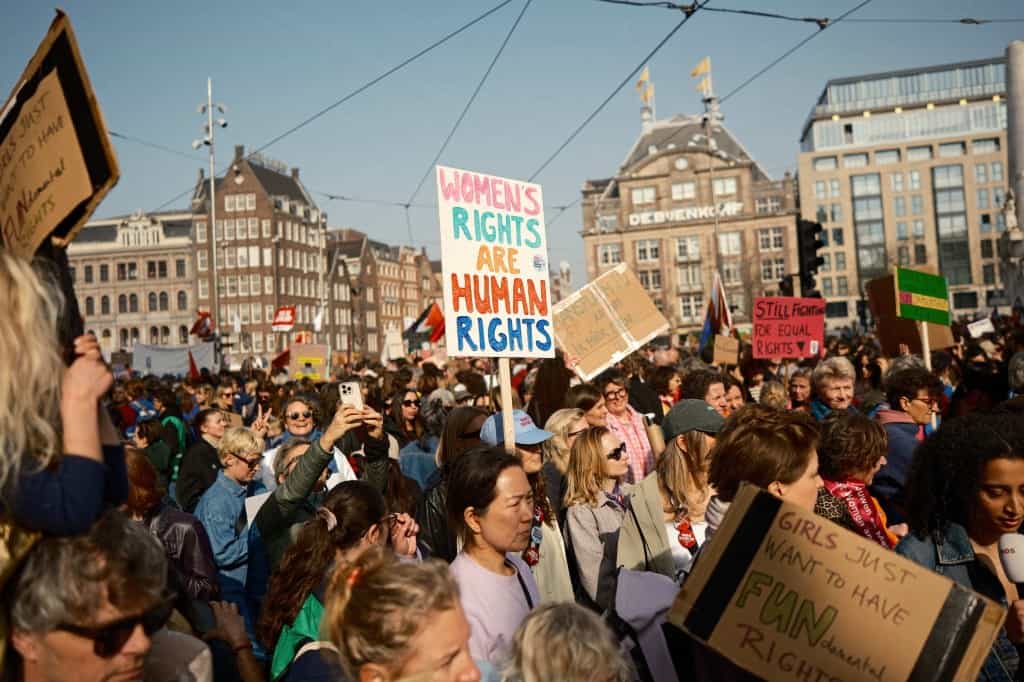 شرکتکنندگان در ۸ مارس ۲۰۲۶ در خیابانهای آمستردام، هلند، در تظاهرات روز جهانی زن، با در دست داشتن پلاکاردهایی در حمایت از برابری جنسیتی راهپیمایی کردند