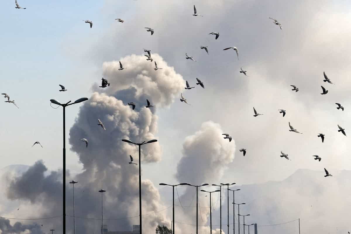 پرندگان در پس زمینه دود برخاسته از حمله به پایتخت ایران، تهران، در ۵ مارس ۲۰۲۶، پرواز می‌کنند.