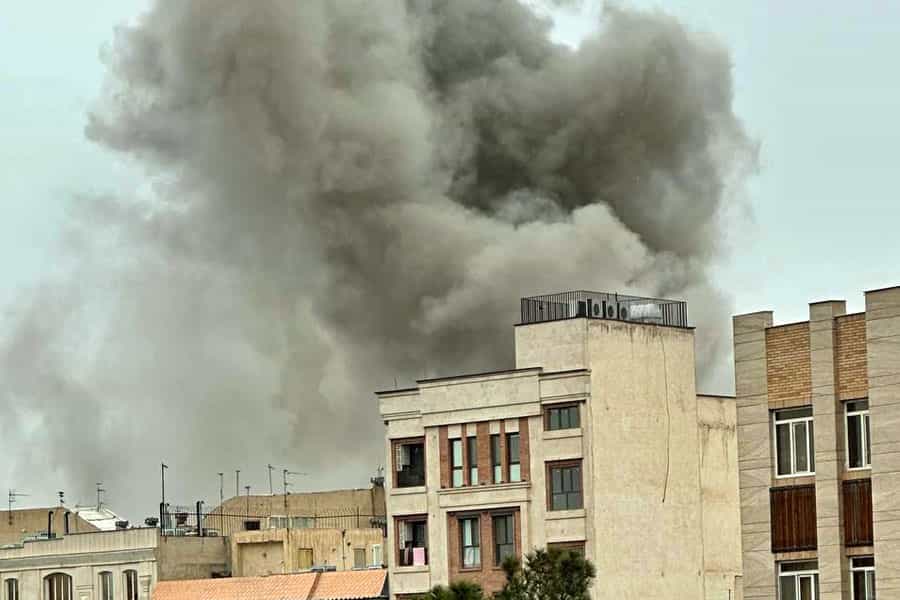 از پشت چند ساختمان دود ناشی از انفجار به آسمان بلند شده است.