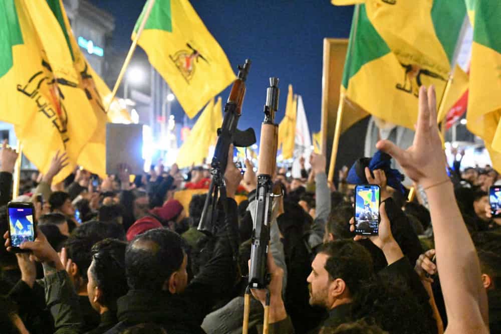 طرفداران گروه «کتائب حزبالله» پرچمهای زرد رنگ این گروه را در دست دارند. برخی از آنها مسلح هستند.