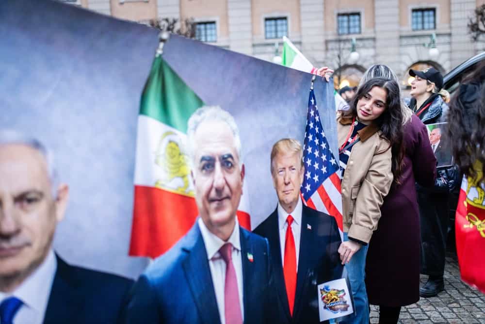 تظاهرات در میدان سرگلز در استکهلم و پرچم با عکس پهلوی و ترامپ و بی بی