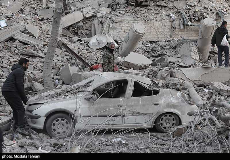 یک ماشین ویران شده در حمله نظامی و سه مرد