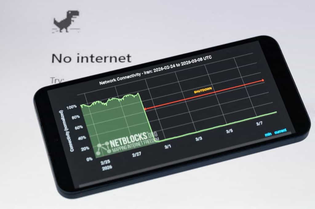 در این تصویرسازی، یک گرافیک NetBlocks قطعی اینترنت در ایران را بر روی صفحه نمایش یک گوشی هوشمند نشان می‌دهد، زیرا مقامات یک خاموشی اینترنتی سراسری را حفظ می‌کنند که اتصال ملی را در طول درگیری و ناآرامی‌های مداوم به حدود 1 درصد از سطح عادی کاهش می‌دهد.