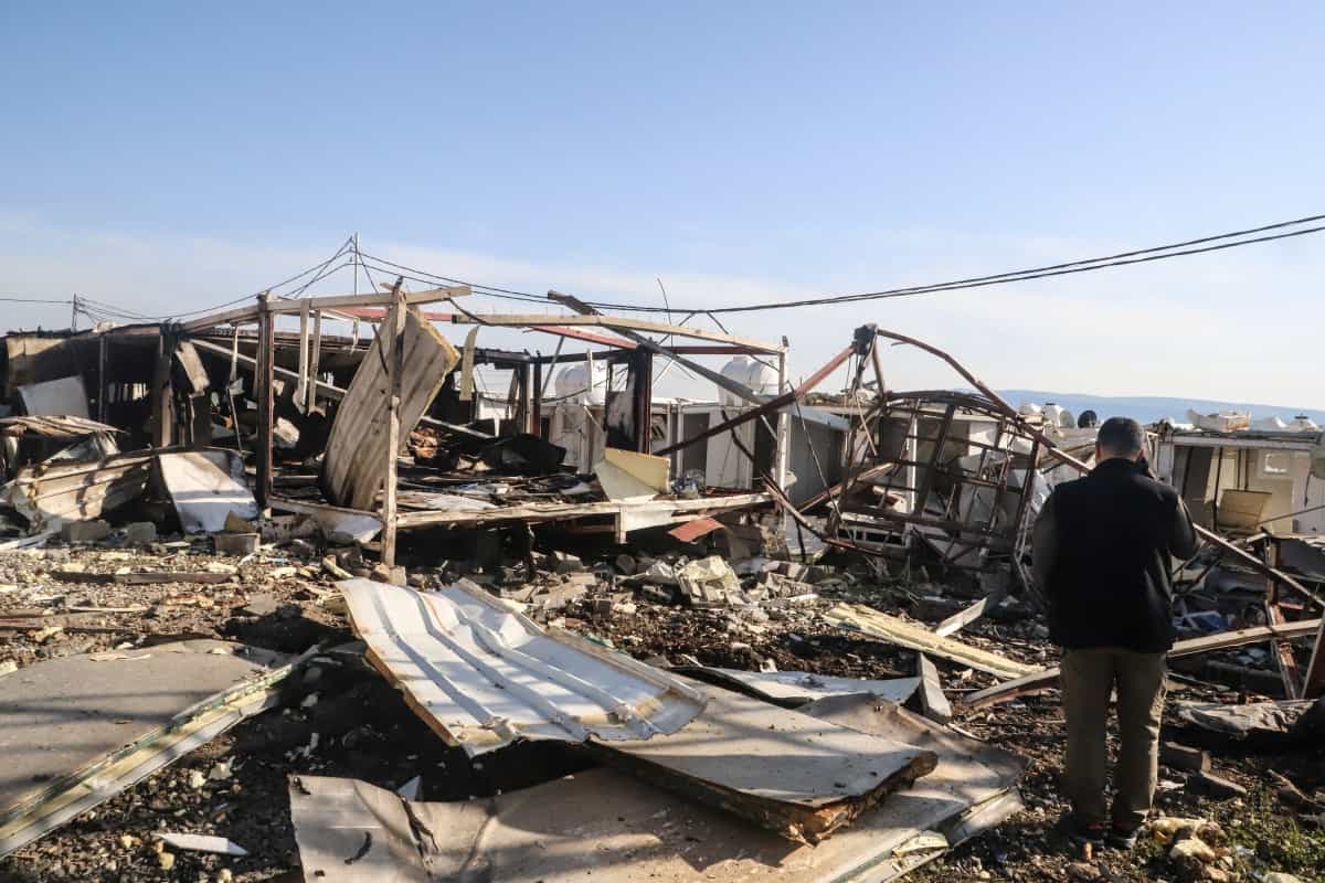 یکی از اعضای حزب کومله به بقایای سازه‌های درهم‌شکسته پس از حملات پهپادی به اردوگاه سورداش حزب اپوزیسیون کرد ایرانی کومله نگاه می‌کند.