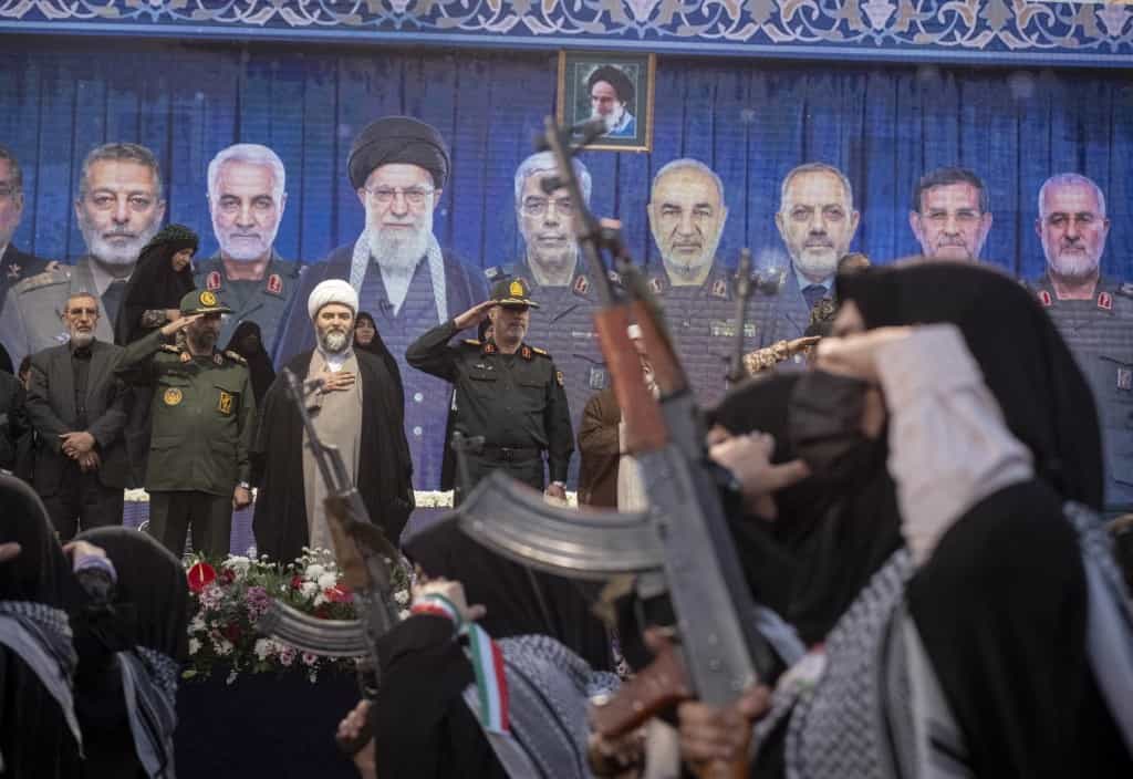 فرماندهان سپاه پاسداران انقلاب اسلامی در حالی که زنان مسلح در یک رژه نظامی در مرکز شهر تهران، ایران، در 29 فروردین 1405 رژه می‌روند، ادای احترام می‌کنند. این رویداد در طول آتش‌بس بین ایران و ائتلاف ایالات متحده-اسرائیل رخ می‌دهد.