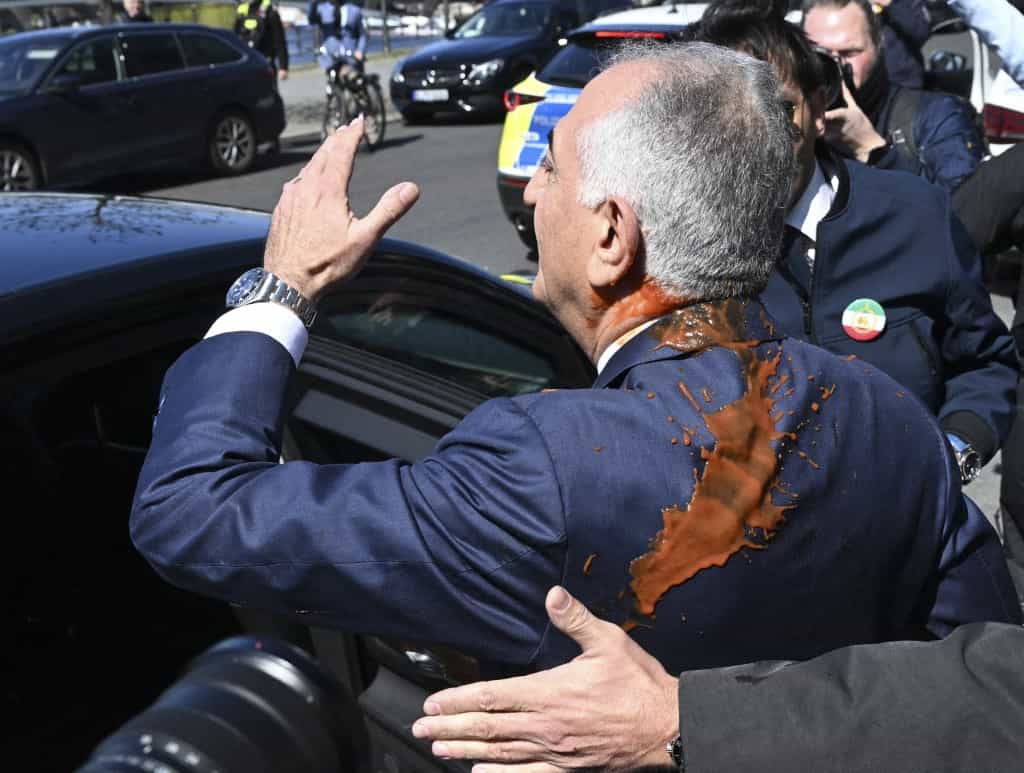 رضا پهلوی، رهبر اپوزیسیون سیاسی ایرانی در تبعید و پسر محمدرضا پهلوی، شاه مخلوع ایران، پس از آنکه پس از مصاحبه پهلوی با رسانه‌ها در ۲۳ آوریل ۲۰۲۶ در برلین، آلمان، از پشت توسط یک مهاجم با ماده‌ای حاوی گوجه‌فرنگی مورد حمله قرار گرفت، آنجا را ترک می‌کند