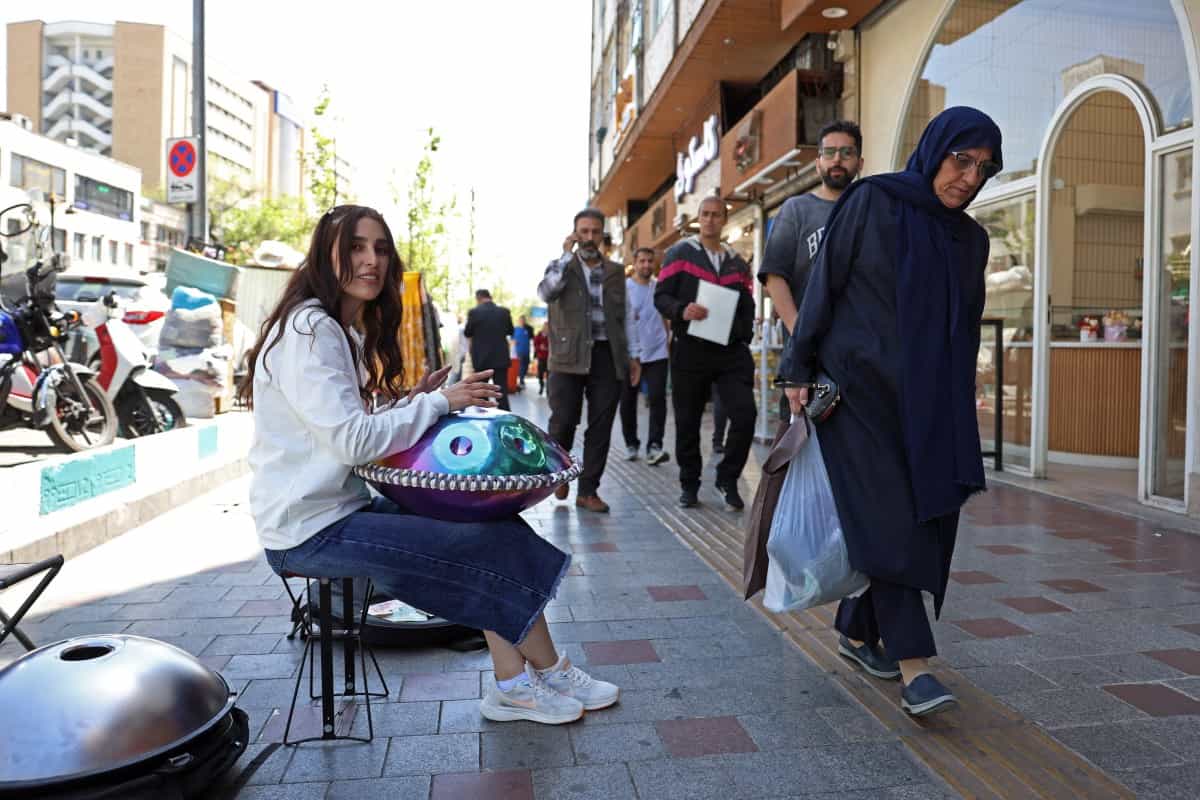 صدف، نوازنده خیابانی ایرانی، در ۲۵ آوریل ۲۰۲۶ در خیابانی در تهران اجرا می‌کند.