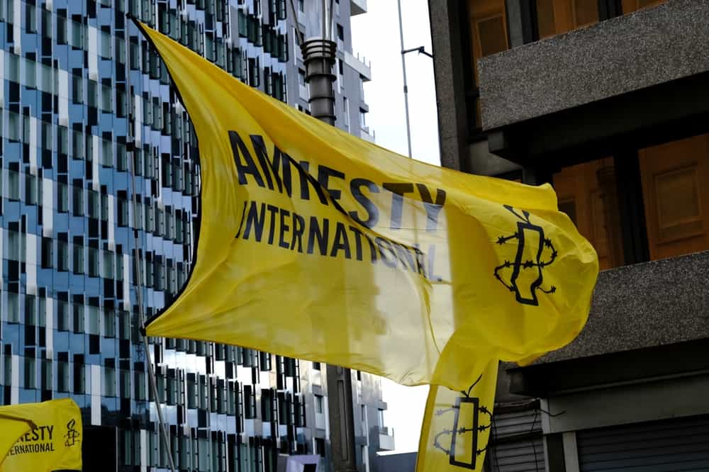 تصویری از پرچم و لوگوی سازمان عفو بین‌الملل