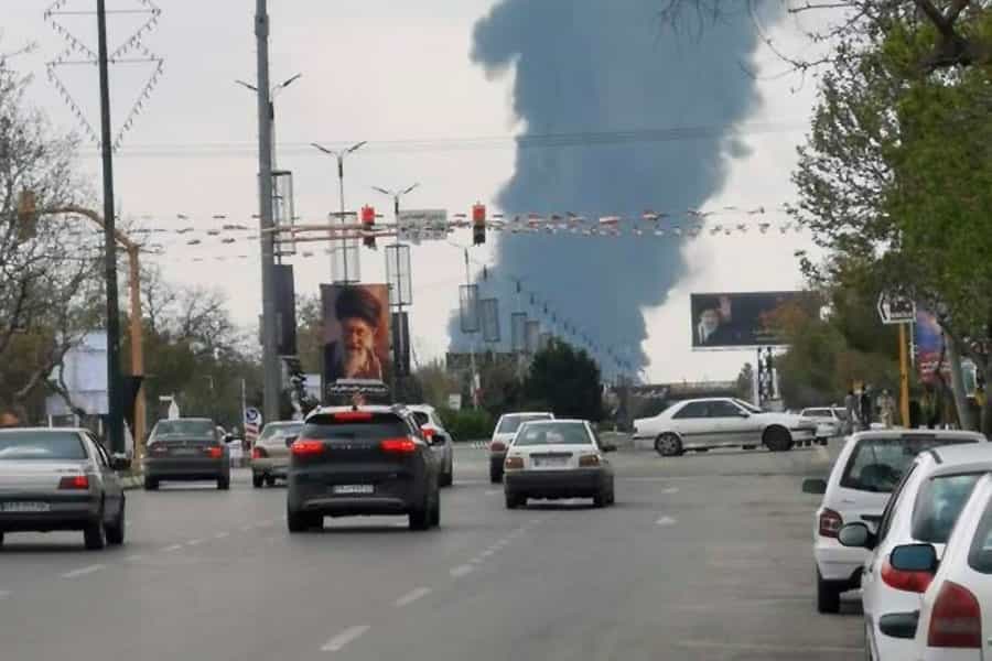 یک بلوار و ستون دود در سمت فرودگاه مشهد در پسزمینه آن. خودروها در بلوار در حال رفت آمدند.