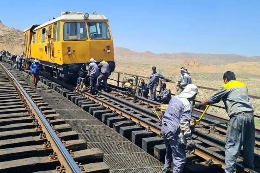 تصویری از کارگران راه‌آهن که در حال کار روی ریل قطار هستند.