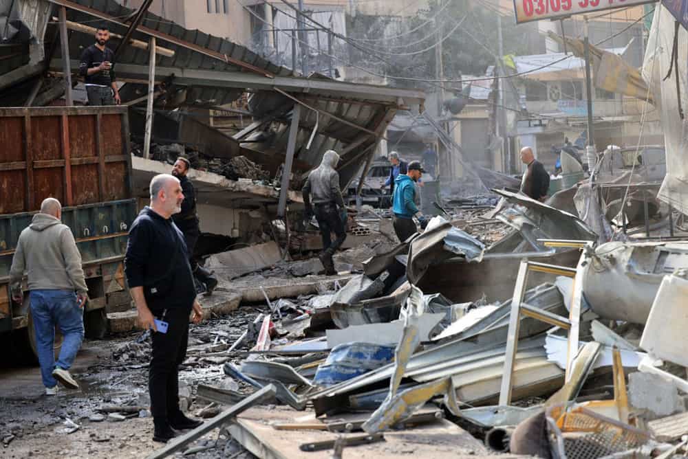 عدهای از مردم منطقه شیاح در حومه جنوبی بیروت در میان آوار پس از حملات هوایی اسرائیل دیده میشوند.