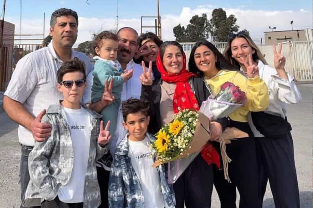 مریم اکبری‌ منفرد در میان اعضای خانواده‌اش دسته‌گلی در دست دارد و می‌خندند.