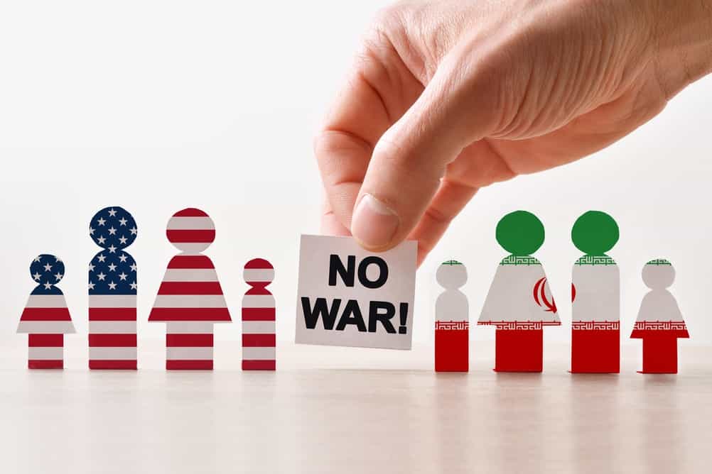 دستی علامت «نه به جنگ» را بین چهره‌های نمادین ایالات متحده و ایران قرار می‌دهد که نشان‌دهنده‌ی حمایت از صلح و مخالفت با درگیری است.